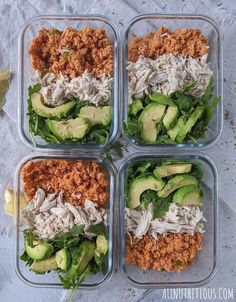 four plastic containers filled with food sitting on top of a white cloth covered tablecloth