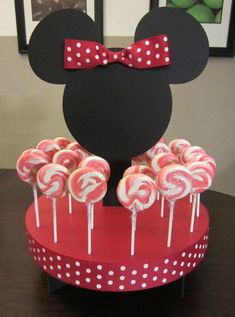 a mickey mouse cake with lollipops in it and the top is red