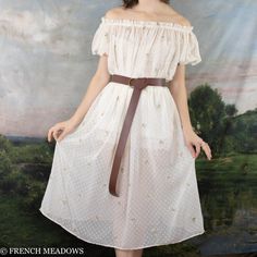 This delicate chiffon dress is as light and airy as a spring blossom in the wind. Embroidered with swiss dots and delicate florals, this whimsical fabric is like a Spring garden you can wear. Puff sleeves add a touch of vintage charm, while the elastic neckline offers versatility, allowing you to wear it on or off the shoulders. While the sheer fabric adds a hint of allure and romance, we recommend pairing this embroidered chiffon dress with a slip or bloomers for modesty if worn on its own. Thi Sheer Chiffon Dress For Spring, Spring Daywear Swiss Dot Dresses, Cottagecore Chiffon Dress For Spring, Spring Swiss Dot Dresses For Daywear, Spring Cottagecore Chiffon Dress, Swiss Dot Dress For Spring Garden Party, Spring Swiss Dot Dress For Garden Party, Cream Swiss Dot Dress For Spring, Cream Swiss Dot Summer Dress