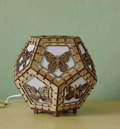 a wooden sculpture with butterflies on it sitting on a table next to a computer mouse