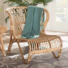 a wicker chair with a blanket on it in front of a potted plant