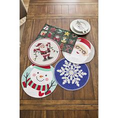 four christmas coasters on a table with snowman, santa clause and other decorations