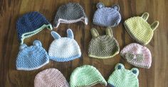 six crocheted hats are laid out on the floor