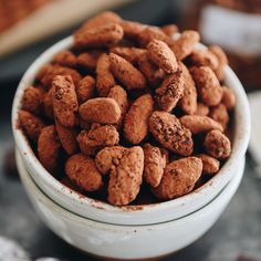 a white bowl filled with nuts on top of a table