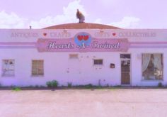 an old white building with hearts painted on it's front and the words heart's tunnel