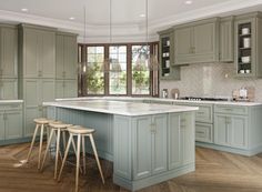 a large kitchen with green cabinets and white counter tops