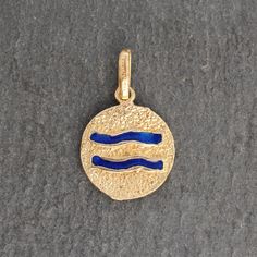 This beautiful vintage Aquarius zodiac pendant is made of 18k yellow gold. It features a double sided style with a textured yellow gold backing and blue, red and green enamel details. ⊹ Vintage 18k Yellow Gold + Enamel⊹ Excellent vintage, pre-owned condition⊹ Diameter: 13.5mm *Note- Pendant does NOT come with chain shown in image- chain is solely shown for perspective* Yellow Gold Zodiac Sign Pendant Jewelry, Round Zodiac Sign Jewelry Collectible, Collectible Round Zodiac Sign Jewelry, Symbolic Yellow Gold Enamel Jewelry, Zodiac Pendant, Aquarius Zodiac, Green Enamel, Gold Enamel, Bracelets And Charms