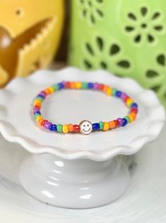 Everyone can use a little dose of happy and, to be honest, it’s hard not to smile back at these cute little stretch bracelets. Need a little mood boost? Just glance at your wrist! Glass beads frame a single enamel in metal smiley face. She measures about 7 inches around. If you need a different length, please just let us know. Cheerful Adjustable Multicolor Friendship Bracelets, Cheerful Multicolor Adjustable Friendship Bracelets, Cheerful Adjustable Friendship Bracelets As Gift, Adjustable Rainbow Beaded Bracelets Playful Style, Adjustable Rainbow Beaded Bracelets, Playful Style, Adjustable Rainbow Beaded Bracelets In Playful Style, Adjustable Multicolor Hypoallergenic Stretch Bracelet, Playful Adjustable Bracelets With Tiny Beads, Fun Adjustable Rainbow Beaded Bracelets