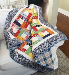 a quilted blanket sitting on top of a white chair