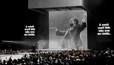 a man standing on top of a stage in front of a crowd