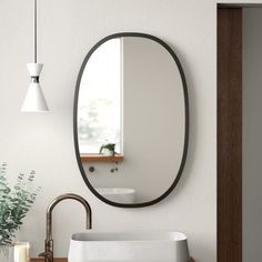 a bathroom sink sitting under a mirror next to a faucet mounted on a wall