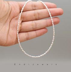 The choker showcases tiny rice-shaped freshwater pearls, each pearl measuring approximately 1.5mm. The small size and distinctive shape of the pearls contribute to the dainty and refined nature of the choker. The pearls are a pure and classic white, emphasizing their natural beauty. White pearls are known for their timeless appeal and versatility, making them suitable for a wide range of styles and occasions. Despite their small size, the tiny rice pearls are expected to exhibit a beautiful lust Minimalist Pearl Necklace With Tiny Beads, Minimalist Pearl White Pearl Necklace With Tiny Beads, Minimalist Pearl White Necklace With Tiny Beads, Minimalist Pearl Beaded Necklaces With Tiny Beads, Minimalist Pearl Beaded Necklace With Tiny Beads, Pearl Necklace With Tiny Beads For Jewelry Making, Tiny White Pearl Jewelry, Minimalist White Pearl Necklace With Tiny Beads, Dainty Pearl White Necklace With Tiny Beads