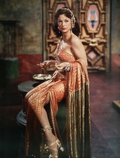 a woman in an orange dress sitting on a table