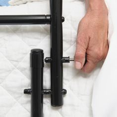 a person is holding the handles on a bed frame that has been made out of black pipes