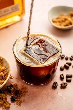 there is a drink with ice and coffee beans on the table