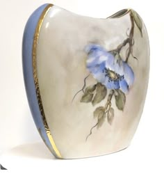 a blue and white vase sitting on top of a table next to a white wall