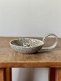 a black and white bowl sitting on top of a wooden table