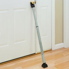 a vacuum cleaner on the floor in front of a door with its handle extended up