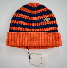 Brand: GUCCI PRODUCT SIZE: M/58/22cm Main color: orange/blue Details: A knitted wool beanie hat in contrasting stripes, subtly embellished with gold bee embroidery-a distinctive symbol of the house. The bee is an archival code first introduced in Gucci ready-to-wear in the 1970's.  Gold embroidered bee appliqué.  Orange and blue striped wool.  Made in Italy. Material: 100% wool.  Condition: new with tags.  100% authentic. United States: USPS Standard Mail - FREE SHIPPING Worldwide Shipping - cos Embroidered Bee, Knitted Wool Beanie, Knitted Accessories, Best Amazon Buys, Bee Embroidery, Gucci Hat, Streetwear Accessories, Gold Bee, Wool Beanie