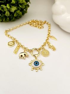 Gold Multi-Charm Necklace - Trendy Gold-Plated Brass Protection Necklace Elevate your style with our exquisite gold multi-charm necklace, crafted from high-quality gold-plated  18 k brass. This trendy necklace features an array of tiny amulets, including a love tag, hand, elephant, round evil eye, and a central horse eye charm, each symbolizing protection and good fortune.  Perfect for those who appreciate both fashion and meaning in their jewelry. Material: Gold-Plated Brass Charms: Hand, Eleph Spiritual Necklace With Dangling Charms As A Gift, Amulet Style Pendant Necklace With Charms, Gold-plated Amulet Style Charm Necklace, Gold Plated Amulet Charms Jewelry, Amulet Style Gold Plated Charm Necklace With Adjustable Chain, Handmade Yellow Gold Charm Necklace For Good Luck, Gold Plated Amulet Charm Necklace With Adjustable Chain, Handmade Yellow Gold Good Luck Charm Necklace, Unique Gold Pendant Charm Necklace