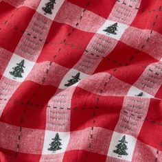 a red and white checkered fabric with trees on it