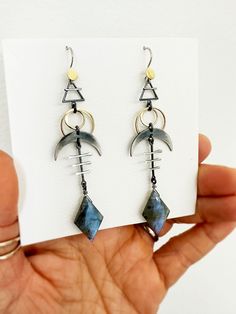 These cosmic sign earrings are rich with cosmic symbols - earth element, solar eclipse, and crescent moon - that together help with emotional balance and to protect against negative energies.  The diamond shaped labradorite is an additional layer of protection. It fills our aura with positivity, giving us the emotional strength and will to go through difficult spiritual transformations. I oxidize and hand finish some of the sterling silver elements to bring out contrast, and achieve an ombre eff Spiritual Crescent Nickel-free Earrings, Celestial Moon Phase Earrings, Celestial Moon Phase Moon Earrings, Celestial Half Moon Earrings With Moon Phase Detail, Celestial Moon-shaped Metal Earrings, Celestial Half Moon Phase Earrings, Unique Moon Phase Jewelry, Modern Sterling Silver Moon-shaped Jewelry, Modern Sterling Silver Moon Jewelry