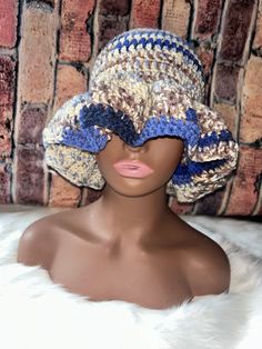 a mannequin head wearing a crocheted hat on top of a white fur