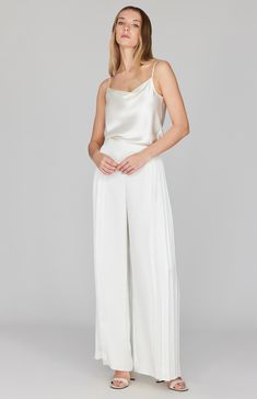 A wide leg pant featuring dramatic pleating at the sides. This pant moves beautifully as you walk and is an unexpected way to do special occasion. Finished with a back zip to maintain a clean front, this pant pairs perfectly with a matching camisole or layered with the pleat back collared shirt. Elegant Silk Wedding Pants, Elegant Straight Leg Wedding Bottoms, Sleek Wide Leg Pants For Spring Evenings, Sleek Wide Leg Pants For Evening In Spring, Sleek Wide Leg Pants For Evening And Spring, Pleated High-waisted Wide Leg Pants For Evening, Sleek Evening Wide Leg Pants For Spring, Evening Pleated High-waisted Wide Leg Pants, Elegant Silk Wedding Bottoms