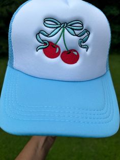 Embroidered bow and cherries trucker cap front adorned with eyelets mesh back with snap closure Summer Mesh Hat With Curved Visor, Summer Mesh Baseball Cap With Curved Visor, White Mesh Trucker Hat For Spring, Spring Mesh Baseball Cap, White Mesh Snapback Hat For Spring, Spring Mesh Trucker Hat With Curved Brim, Spring Mesh Snapback Hat With Curved Bill, Spring Mesh Snapback Cap, Spring Mesh Cap