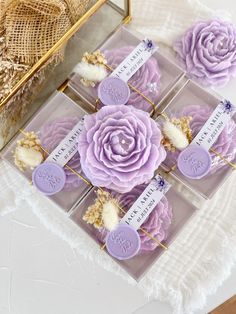 purple flowers are placed in clear acrylic boxes