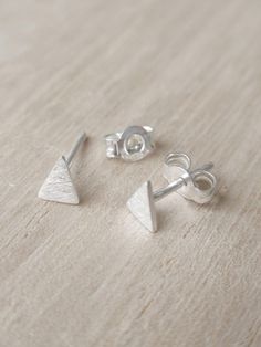 ELEMENTAL GEOMETRY Geometric figures allow us to understand the world and introduce us to the language of shapes. Here we try to reduce them to their minimum expression to accentuate their perfection and beauty. MINI TRIANGLE These tiny triangular earrings are handmade in Barcelona and are made of silver, just like the chain. CARE IN EVERY DETAIL Our pieces are made with great care and dedication, paying special attention to ensuring that the production process from the original design to the fi Triangle Stud Earrings, Marcasite Jewelry, Triangle Earrings Stud, Triangle Studs, Geometric Studs, Tiny Studs, Skin Products, Tiny Stud Earrings, Stud Set