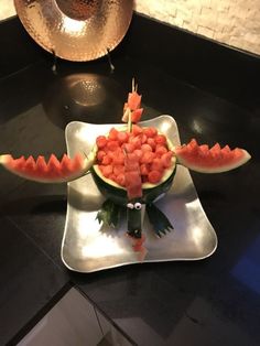 a watermelon sculpture made to look like an alligator's mouth is displayed on a plate