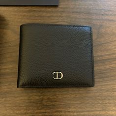 Like New Christian Dior Bifold Wallet, With Black Grained Calfskin And Cd Icon Signature (Finished In Ruthenium Brass). Has Interior Dior Embossing, Snap Button Compartment For Coins, Double Bill Holder Pockets, Two Flat Compartments And Four Card Slots. Includes Original Box And Purchase Bag. Dimensions: 4.5in X 4in. Designer Leather Wallet With Smooth Grain, Designer Leather Wallet With Leather Lining, Designer Wallets With Leather Lining For Formal Occasions, Designer Black Wallets With Leather Lining, Luxury Leather Wallet With Coin Pocket, High-end Leather Wallet For Formal Use, Designer Rfid Blocking Wallet For Formal Occasions, High-end Leather Wallets For Formal Occasions, Designer Bifold Wallets For Formal Occasions