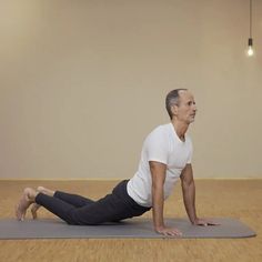 an older man is doing yoga on a mat