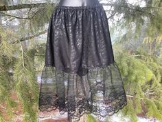 Black floral fabric Skirt or Slip with adjustable elastic waist. Skirt with lace ruffles.   Large size Slip measurement  30 inches wide elastic adjustable waist  25 inches long from top of of waist to bottom of ruffles.  12 inches long lace ruffles finished.  Hand spot wash only.  Hang dry. Lace Tiered Mini Skirt With Lace Trim, Tiered Lace Mini Skirt With Lace Trim, Lace Trim Tiered Mini Skirt, Lace Ruffled Tiered Skirt Bottoms, Lace Tiered Mini Skirt For Party, Stretch Lace Mini Skirt With Lace Trim, Gothic Fitted Lace Bottoms, Stretch Lace Trim Skirt, Gothic Stretch Ruffle Bottoms