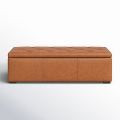 a tan leather bench with buttons on the back and seat cushiones, sitting against a white background