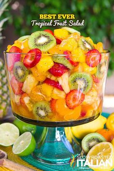 a fruit salad with kiwis, oranges and strawberries in a glass bowl