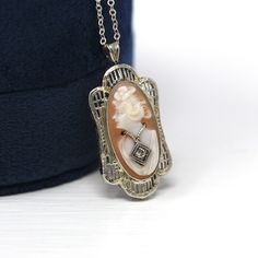 "Beautiful vintage circa 1930s Art Deco era 14k white gold cameo necklace! This stylish pendant features a carved shell cameo, in an intricate filigree setting. The cameo is depicted wearing a Habillé style genuine diamond necklace, and the charm is shown modeled on a brand new 20\" sterling silver chain. A timeless cameo necklace, from the 1930s!  ERA - Circa 1930s - Art Deco METAL / MATERIAL - 14k white gold pendant, shell, genuine diamond (approx. .02 CT) MARKINGS / HISTORY - There are no mar Victorian White Gold Pendant Necklace, White Gold Oval Filigree Necklace, White Gold Filigree Necklace In Oval Shape, Oval White Gold Filigree Necklace, Art Deco White Gold Round Necklaces, Oval Filigree Necklaces For Anniversary, Classic Pendant Necklace With Filigree, Classic Filigree Necklace For Anniversary, Antique White Gold Pendant Necklace