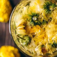 a jar filled with yellow flowers on top of a wooden table