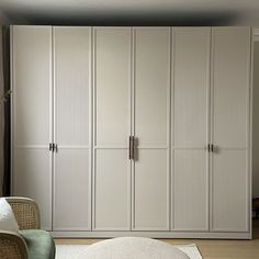 a bedroom with white closets and a round ottoman on the floor in front of it