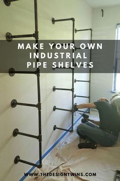 a man laying on the ground in front of pipes that have been installed to make your own industrial pipe shelves