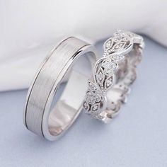 two wedding bands with diamonds on each side, one is white gold and the other is silver