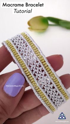 a woman's hand holding a crochet bracelet with yellow and white beads