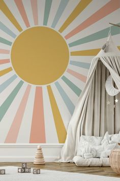 a child's bedroom with sunburst wallpaper and bedding in pastel colors