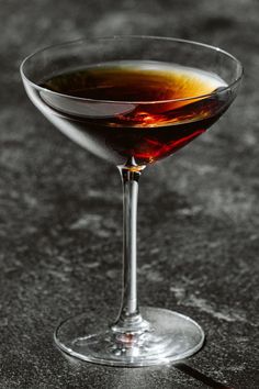 a glass filled with liquid sitting on top of a table