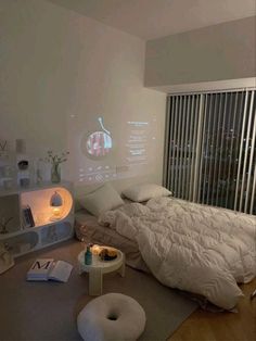 a bed room with a large white bed and a projector screen on the wall