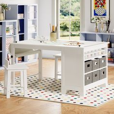 a child's desk and chair in a room with wooden floors, blue walls and white furniture