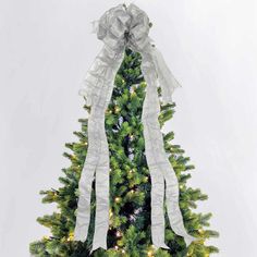 a decorated christmas tree with white ribbon and lights