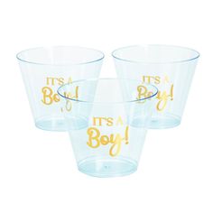 three clear plastic cups with gold lettering on the bottom, one says it's a boy and the other says it's a boy