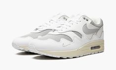 The Patta x Nike Air Max 1 “White” is a collaboration between the famed Amsterdam sneaker boutique and Nike on the retro running shoe in a neutral-based colorway.  Patta and Nike memorably collaborated on several Air Max 1 colorways in 2021, and the “White” reunites the longtime partners in sneaker design.  This “White” colorway, like Patta’s Air Max 1’s from 2021, offers a new twist on the silhouette with a wavy pattern on the mudguard, this time in white leather.  The look is subtle but gives Patta Air Max 1, Nike Patta, Nike Air Max 1 Patta, Nike Air Max White, Retro Running Shoes, Sneakers Box, Kobe Shoes, Sneaker Design, Sneaker Boutique